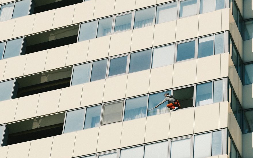 Window cleaner working on the glass facade of a high rise