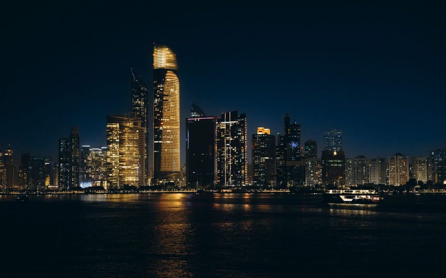 Abu Dhabi towers lit up at night along the waterfront
