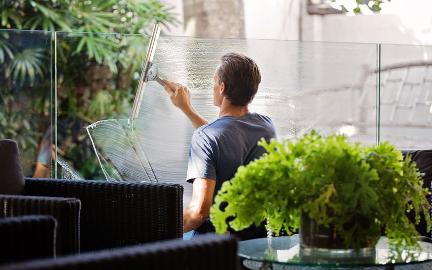 Man cleaning a glass wall with a squeegee