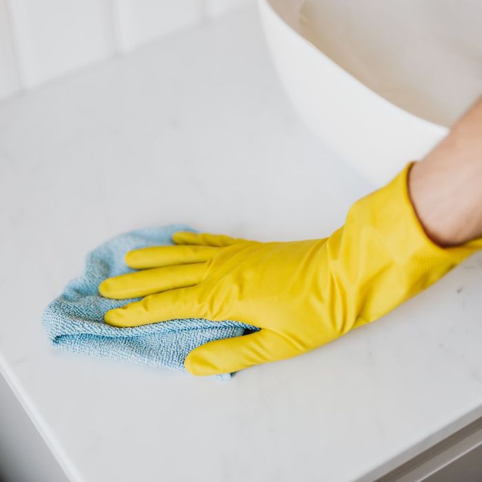Wiping a kitchen counter with a microfibre cloth